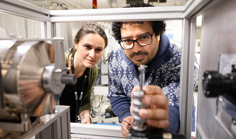 Two researchers working with advanced equipment in a laboratory